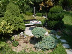 un jardin avec un banc au milieu de quelques buissons dans l'établissement Apartment Monte Rosa, à Delnice