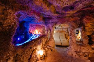 une grotte avec une cheminée au mur dans l'établissement Pensiunea Casa Zanelor, à Floreşti