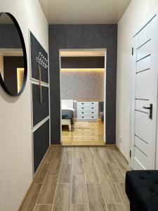 a hallway with a bedroom with a bed and a mirror at Апартаменты Well - Being in Umanʼ