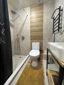 a bathroom with a toilet and a sink and a shower at Апартаменты Well - Being in Umanʼ