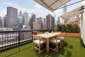 een tafel en stoelen op een balkon met een skyline van de stad bij 33 Hotel, New York City, Seaport in New York