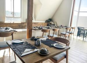 une salle à manger avec des tables et des chaises et de la vaisselle dans l'établissement Swakopmund Luxury Suites, à Swakopmund