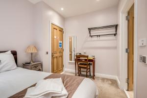 1 dormitorio con 1 cama y escritorio con silla en Central Belfast Apartments Harpers, en Belfast