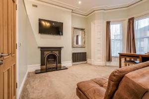 sala de estar con chimenea y TV en la pared en Central Belfast Apartments Harpers, en Belfast