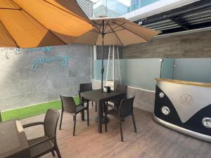 - une salle à manger avec une table, des chaises et un parasol dans l'établissement Hotel Villas Santander, à Guatemala