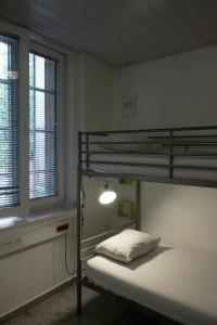 um quarto com 2 beliches e um candeeiro em Hostel 24 em Liubliana