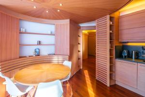 a kitchen and dining room with a wooden table and chairs at Terrazza su Sestriere Lux in Sestriere