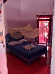 um quarto com uma cama e uma rede mosquiteira em Il Triangolo Hostel em Las Galeras