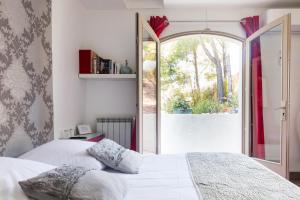 1 dormitorio con cama y ventana grande en Le Mas des Roches à Velaux, en Velaux