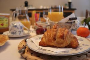 um prato com um croissant numa mesa em Les Tourelles em La Tour-du-Pin