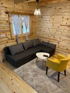 a living room with a black couch and a table at Apartments Milev in Mokra Gora