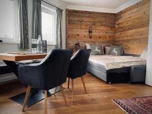 um quarto com uma cama, uma secretária e cadeiras em Apartment close to the ski area em Wald im Pinzgau