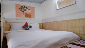 - une chambre avec un grand lit et des draps blancs dans l'établissement 296 Cetete - Home in Dalat, à Đà Lạt