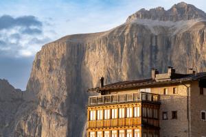 budynek z górą w tle w obiekcie Hotel Pordoi Passo Pordoi Vegetarian Hotel w mieście Canazei