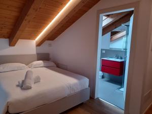 a bedroom with a bed and a bathroom with a sink at Superior Beach Aparthotel in Lido di Jesolo