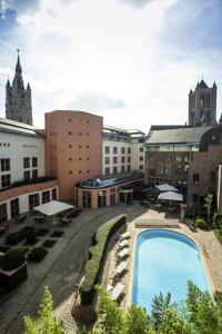 a hotel with a swimming pool in a courtyard at Novotel Gent Centrum in Ghent