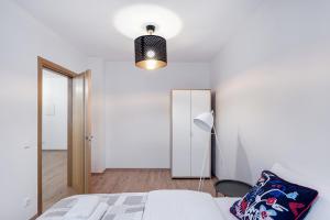 a bedroom with a bed and a lamp and a mirror at Business Apartment In Jaksto Street in Vilnius