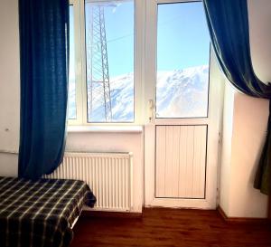 a window with a view of a snow covered mountain at YETI-clubcom in Gudauri