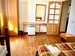 a room with a bed and a desk and a mirror at YETI-clubcom in Gudauri