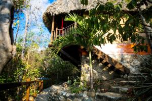 een huis met een trap naar een balkon bij Hotel El Copal in Mazunte