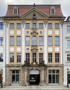 ein großes gelbes Gebäude mit Zugang in der Unterkunft Hotel Sonne in Zittau