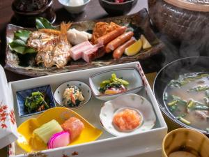 een dienblad gevuld met verschillende soorten voedsel op een tafel bij Bettei Fujiya in Miyajima