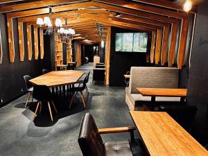 a dining room with wooden tables and chairs at Namba Guesthouse HIVE in Osaka