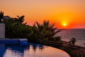 einen Pool mit Sonnenuntergang im Hintergrund in der Unterkunft Villa Mavi Manzara in Kaş