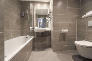 een badkamer met een wastafel, een toilet en een bad bij Best Western Plus Hotel Du Parc Chantilly in Chantilly