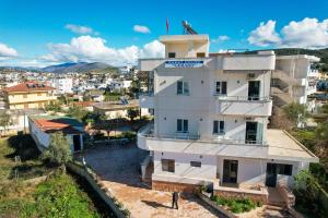 Un bâtiment avec un homme debout en haut dans l'établissement Guest House Gerard, à Ksamil