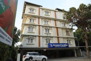 un coche blanco estacionado frente a un edificio en Dreams Paradise Airport Residency, en Nedumbassery