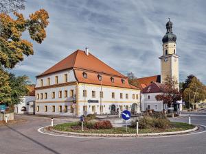 um grande edifício com uma torre de relógio numa rua em Hofwirthotel em Sankt Martin im Innkreis