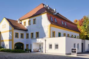 um grande edifício branco com um telhado castanho em Hofwirthotel em Sankt Martin im Innkreis