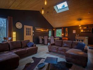 ein großes Wohnzimmer mit Sofas und einer Uhr an der Wand in der Unterkunft A L OREE DU BOIS in Ferrières