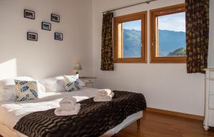 een slaapkamer met een bed met handdoeken erop bij Chalet Brio in Samoëns