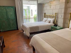 ein Hotelzimmer mit 2 Betten und einem Fenster in der Unterkunft Katari Hotel at Plaza de Armas in Arequipa