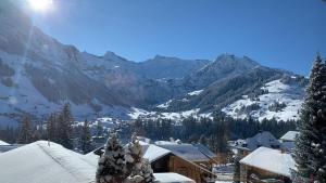 eine schneebedeckte Bergkette mit einer Ski-Lodge in der Unterkunft Chalet-Hotel Beau-Site in Adelboden