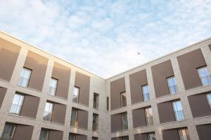 une façade d'un bâtiment avec le ciel en arrière-plan dans l'établissement Holiday Inn - the niu, Amity Potsdam, an IHG Hotel, à Potsdam