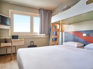 een hotelkamer met een bed en een bureau bij ibis budget Paris Porte d'Aubervilliers in Aubervilliers