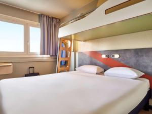 オーベルヴィリエにあるibis budget Paris Porte d'Aubervilliersのベッドルーム(大きな白いベッド1台、窓付)