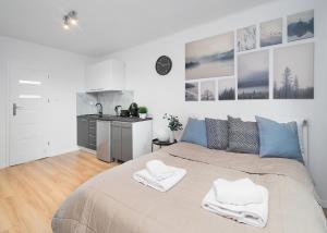 een slaapkamer met een groot bed en 2 witte handdoeken bij Central Apartments Grzybowska in Warschau