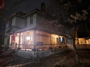 une maison avec terrasse couverte la nuit et drapeau dans l'établissement Downen House Bed & Breakfast, à Pueblo