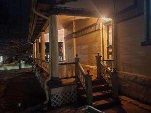 une terrasse couverte d'une maison avec un escalier la nuit dans l'établissement Downen House Bed & Breakfast, à Pueblo