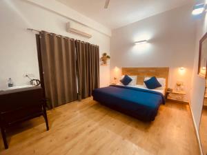 a bedroom with a large blue bed and a sink at Divine Inn Couple Friendly Hotel near Sector 51 Metro Station in Noida