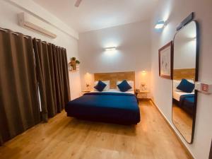 a bedroom with a blue bed and a mirror at Divine Inn Couple Friendly Hotel near Sector 51 Metro Station in Noida