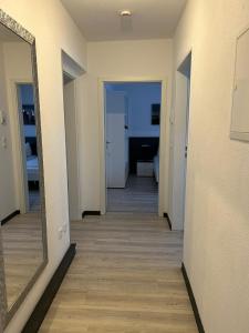 pasillo que conduce a una habitación con espejo en Aparthotel Gartenstadt, en Bamberg