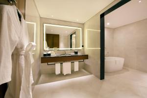 bagno con lavandino e specchio di Asiana Grand Hotel a Dubai