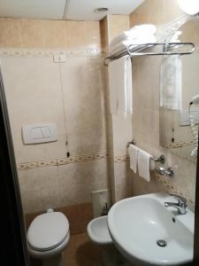 uma casa de banho com um WC branco e um lavatório. em Hotel de Rossi em Bari