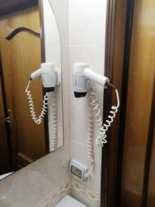 uma casa de banho com dois telefones pendurados na parede em Hotel de Rossi em Bari