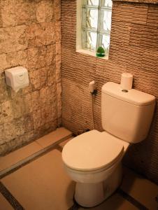 bagno con servizi igienici bianchi e finestra di Amed Cafe & Hotel Kebun Wayan ad Amed